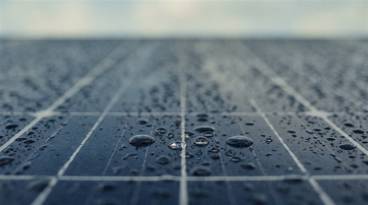Painéis solares molhados de chuva sob céu nublado