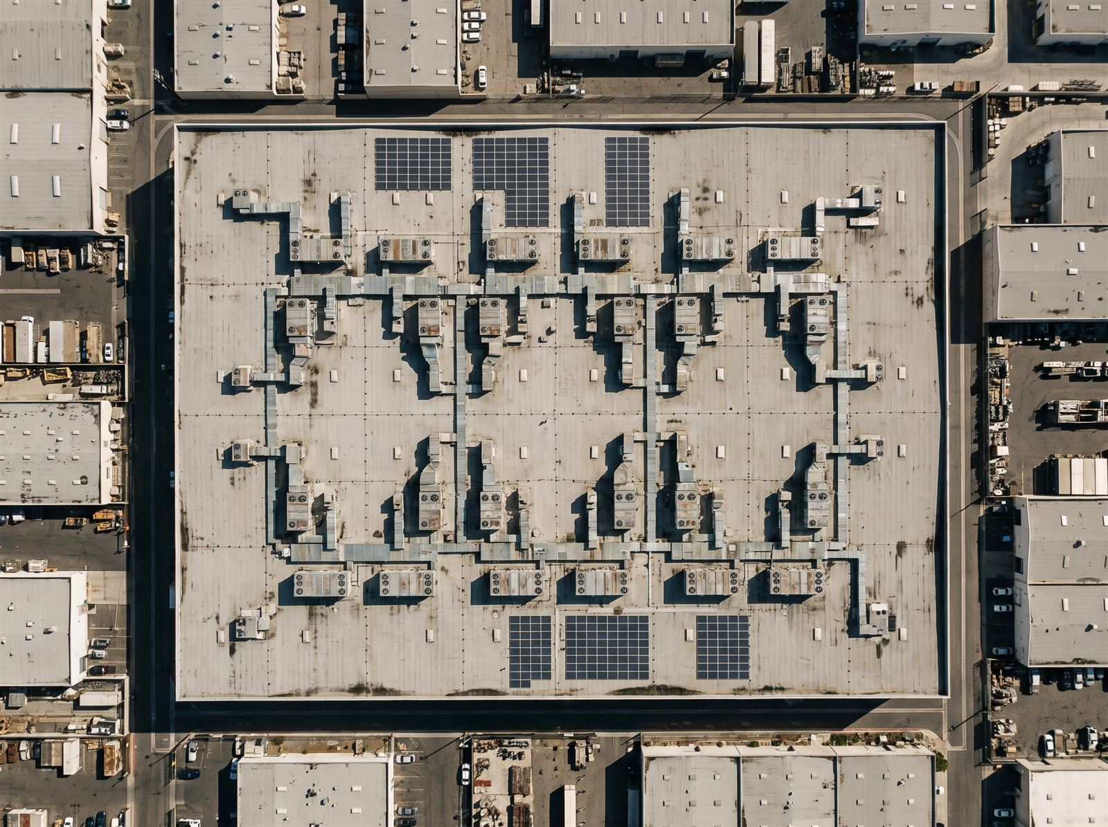 Telhado industrial coberto por painéis solares visto de cima